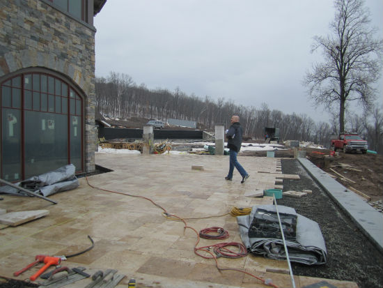 Clubhouse's west terrace with TMS principal, Shannon Alther, looking into the dining room.  Piers at the end are a part of a fence overlooking the pool area with the bocce ball course to the right. Source:  TMS Architects