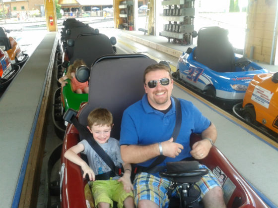 TMS Project Architect Tim Giguere and his son Logan enjoy a ride on a tandem go- kart.